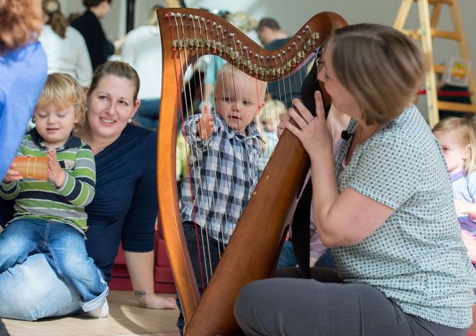 Ein Kleinkind erkundet das Instrument einer Harfenistin auf dem Kleinkinderkonzert der Philharmonie Essen