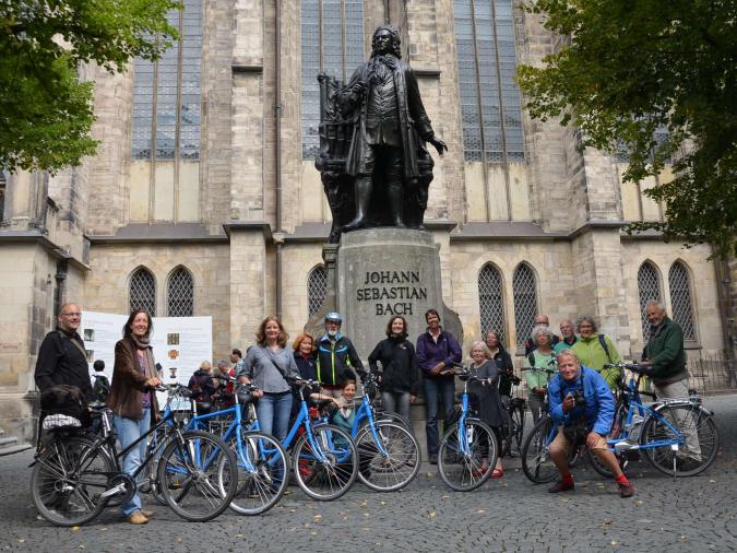 Eine Gruppe Radfahrer vor dem Johann-Sebastian-Bach-Denkmal in Leipzig