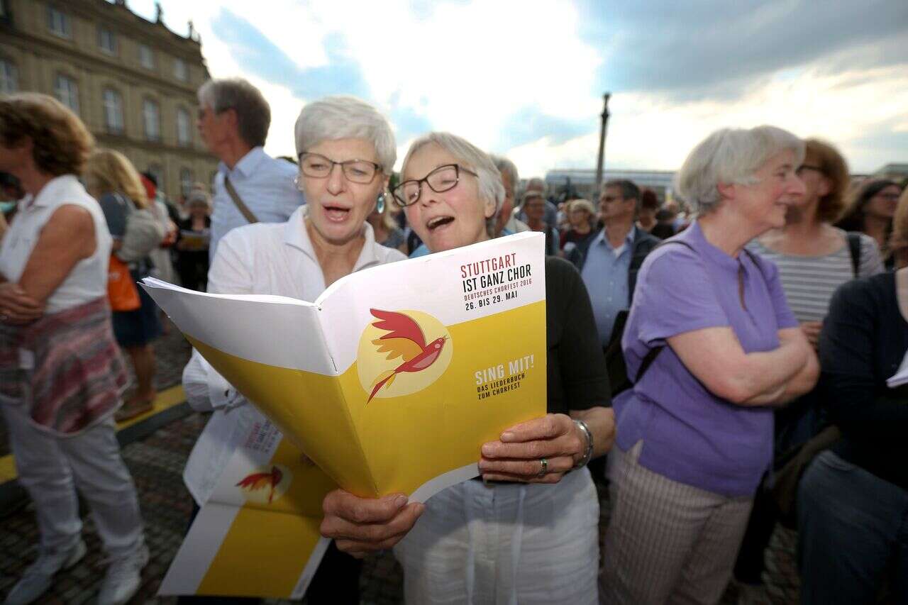 Zwei ältere Damen singen gemeinsam aus einem Notenheft beim Deutschen Chorfest