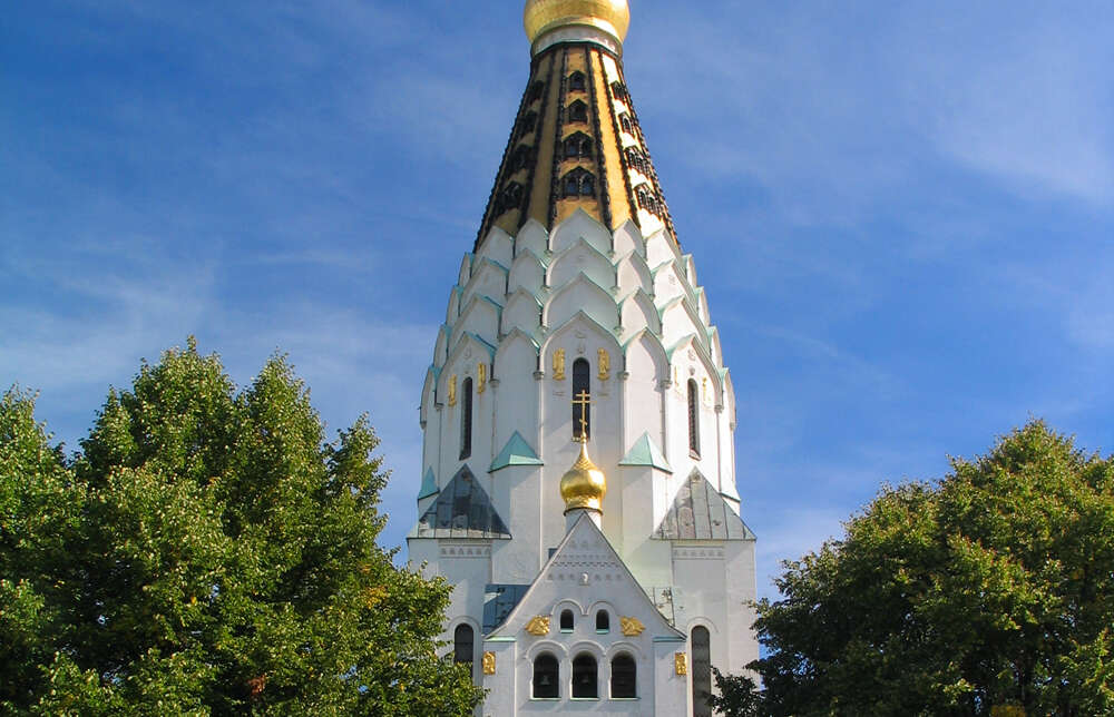 Turm der Russischen Gedächtniskirche in Leipzig mit weißer Fassade und goldener Spitze.