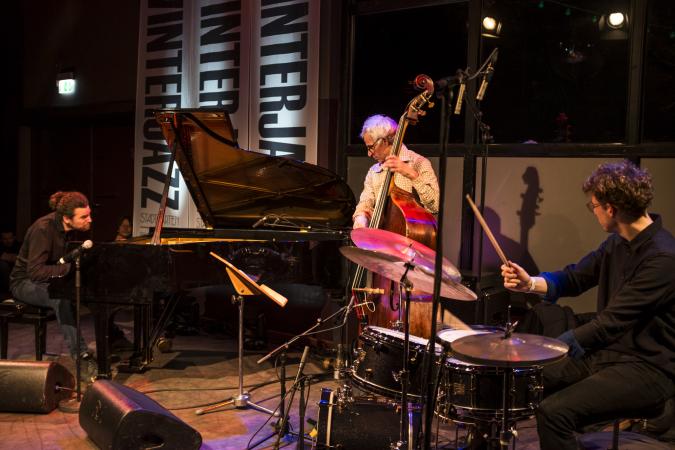 Winterjazz im Stadtgarten Köln: Ein Jazzensemble, bestehend aus Klavier, Kontrabass und Schlagzeug, spielt auf einer Bühne