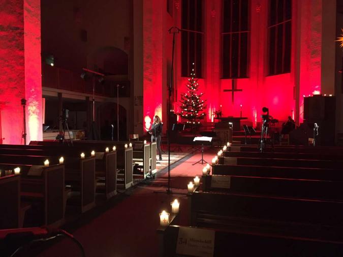 In rotes Licht getauchter Kirchenraum mit Weihnachtsbaum