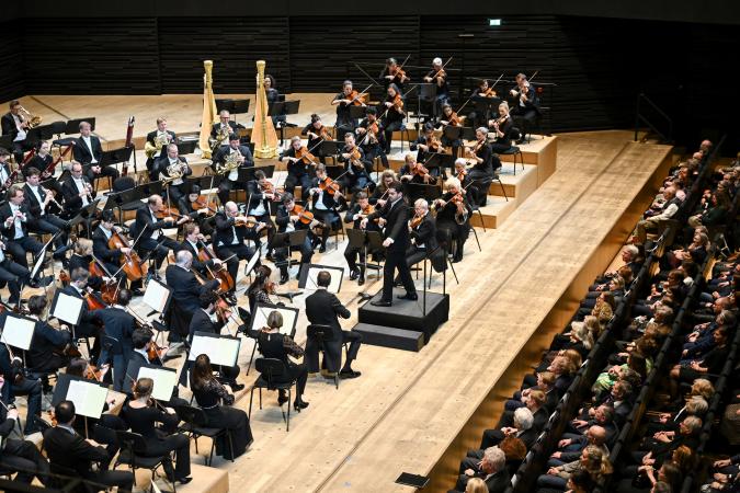 Sinfonieorchester spielt vor voll besetzten ersten Sitzreihen im Konzertsaal