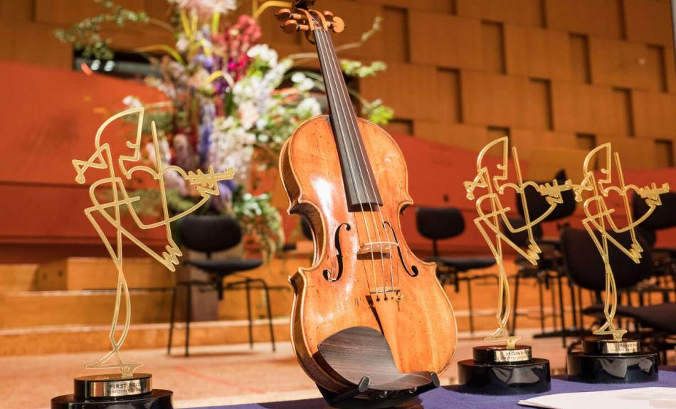 Eine Violine zwischen den Trophäen für den Joseph Joachim Violinwettbewerb 2018.