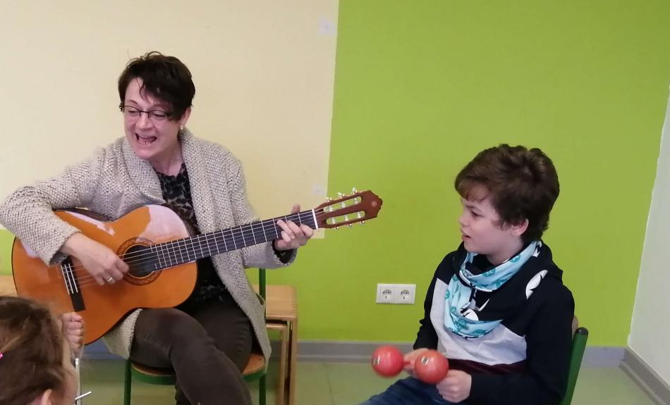 Musikunterricht an der Marienschule in Bad Hönningen. Die Rektorin singt mit den Kindern und begleitet dabei mit der Gitarre.