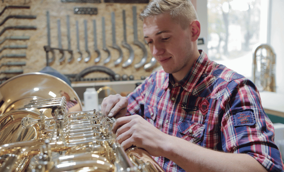 Der Metallblasinstrumentenmacher Philip Josiger beim Bau einer Tuba