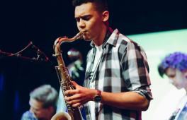 Junger Saxophonist spielt auf einer Bühne