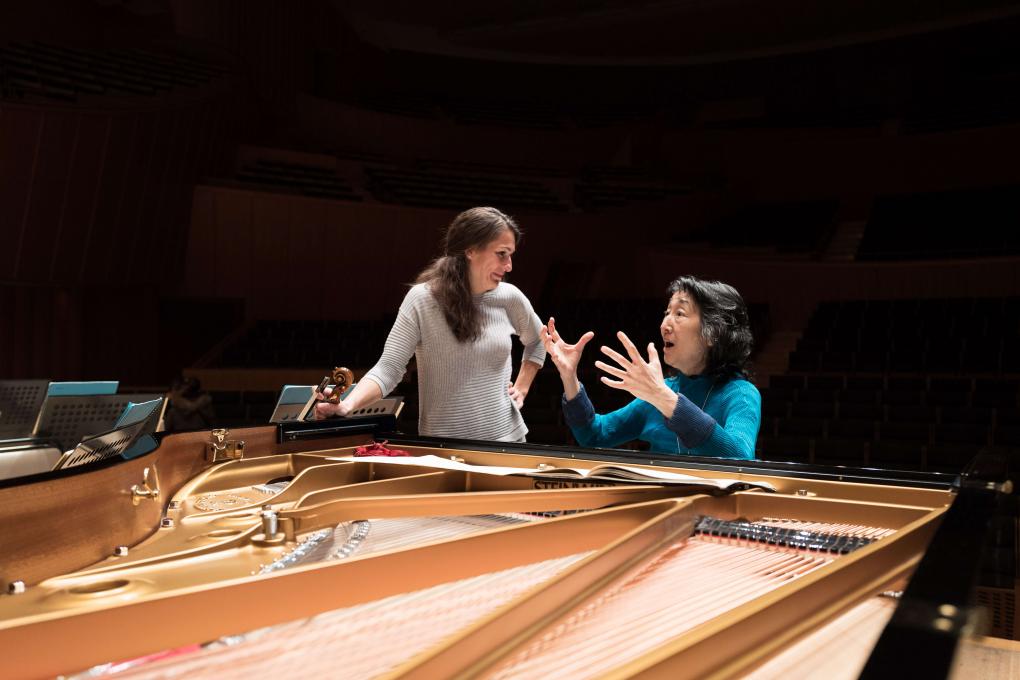 Violinistin Katarzyna Wozniakowska und Artistic Partner Mitsuko Uchida vertieft in lebhafte Unterhaltung an einem Flügel