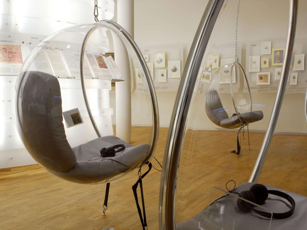 Hängende Sessel mit Kopfhörern in einem Museum